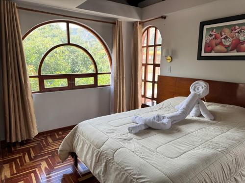 a bedroom with a bed with a stuffed animal on it at Shumaq Guesthouse in Carhuaz