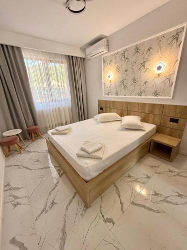 a bedroom with a large bed in a room at Pensiunea Duet in Sărata-Monteoru