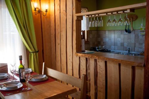 a wooden kitchen with a table with plates and wine glasses at CABAÑAS RACO in Licán Ray