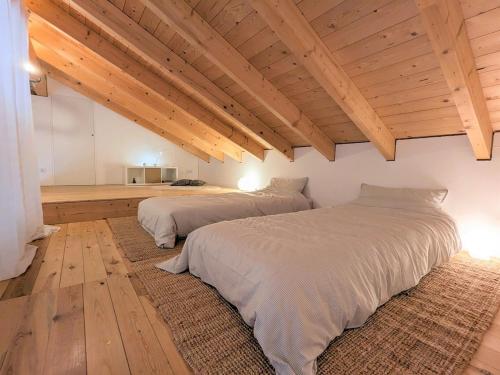 Vacation home with a view of nature, home theater, fireplace في Greifenstein: سريرين في غرفة ذات أسقف خشبية