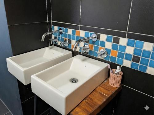 a bathroom sink with two faucets on a wall at Modern Boho Loft- Observatory in Cape Town