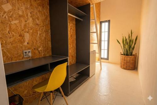a room with a yellow chair and a cabinet at Modern Boho Loft- Observatory in Cape Town
