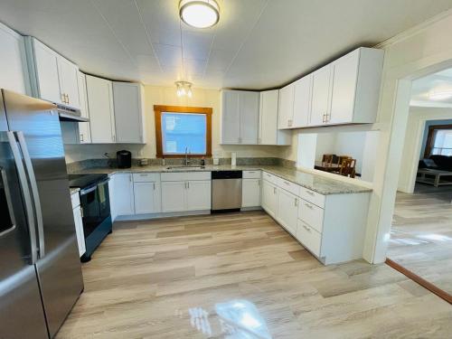 eine Küche mit weißen Schränken und Geräten aus Edelstahl in der Unterkunft Home Sweet Home in Laconia