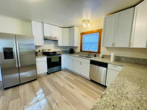 eine Küche mit weißen Schränken und Geräten aus Edelstahl in der Unterkunft Home Sweet Home in Laconia