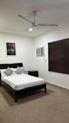 a bedroom with a bed and a ceiling fan at Big & Quiet Apartment in Jurdāb