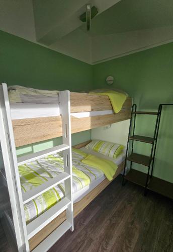 two bunk beds in a room with green walls at Ferienhaus Kammblick in Schmerbach