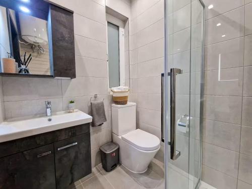 Luxury Qawra Holiday Stay Apartment في خليج سانت بول: حمام مع مرحاض ومغسلة ودش