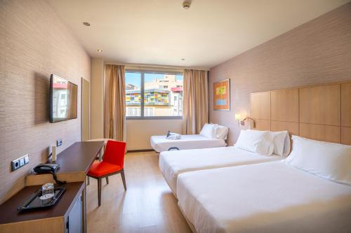 ein Hotelzimmer mit zwei Betten und einem Schreibtisch in der Unterkunft Abba Huesca in Huesca