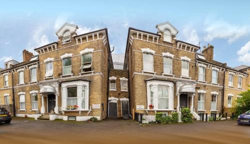 a large brick building with white windows at Amhurst Hotel in London