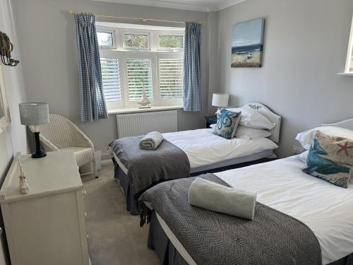 a small bedroom with two beds and a window at Number Twenty Four in West Wittering