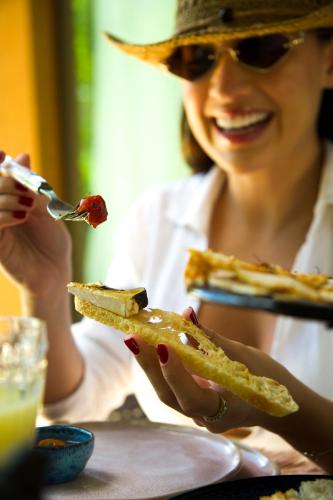 een vrouw aan een tafel eten met een vork bij Umbelina Pousada Boutique in Porto De Galinhas