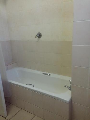a white bath tub sitting in a bathroom at Uitenhage Apartments in Uitenhage