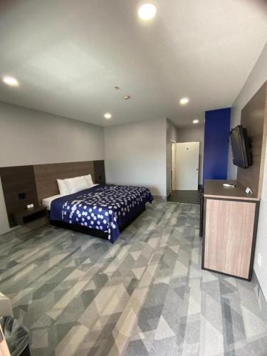 a hotel room with a bed and a flat screen tv at Airway Inn - IAH Airport in Houston