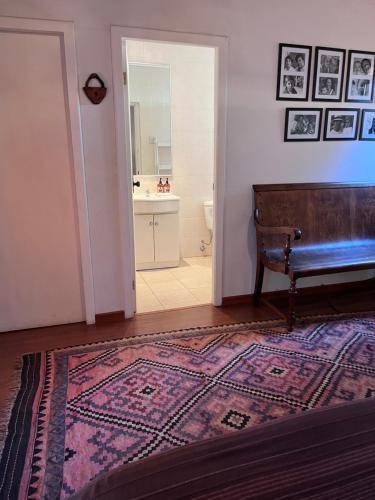 a room with a rug and a bathroom with a sink at Lodge Boutique Casa Cardonal in Paine