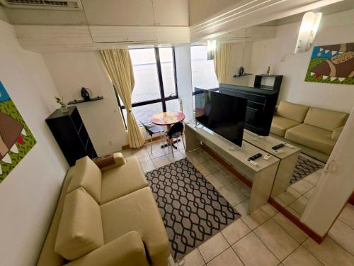 un soggiorno con divano e TV a schermo piatto di tropical Flat Belissimo a Manaus