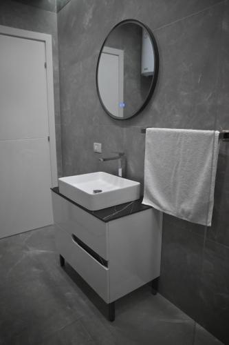 a bathroom with a white sink and a mirror at The Minimalist Escape II in Kamëz