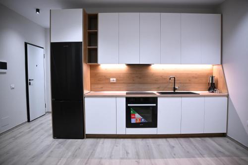 a kitchen with white cabinets and a sink at The Minimalist Escape II in Kamëz