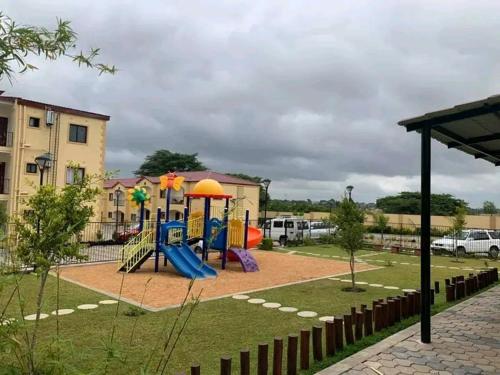 a playground with a slide in a park at Budget apartments near American embassy in Lusaka
