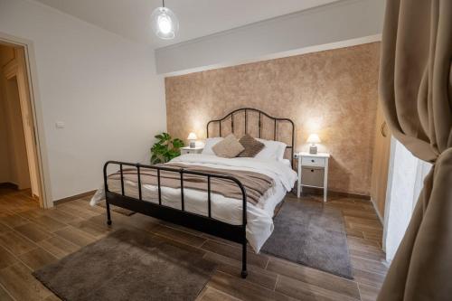 a bedroom with a bed with a metal frame at Danellgio cozy nest apartment in Chalkida