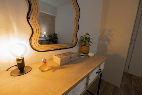 a table with a lamp and a mirror on it at Danellgio cozy nest apartment in Chalkida