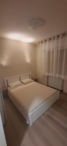 a bedroom with a white bed and a window at Appartamento Padova Chiesanuova in Padova