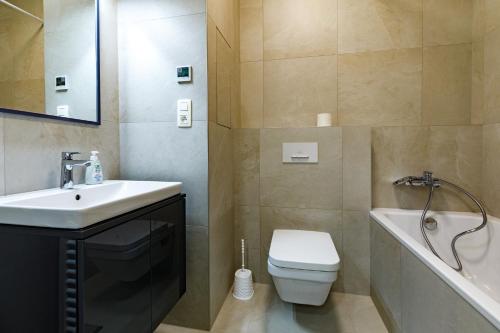 Apartmán Mierova في براتيسلافا: حمام مع حوض ومرحاض وحوض استحمام