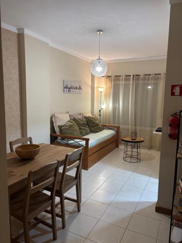 a living room with a table and a bed at AP Roberand in Albufeira