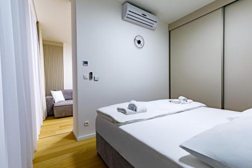 Apartmán Mierova في براتيسلافا: غرفة نوم بها سرير أبيض كبير وكرسي