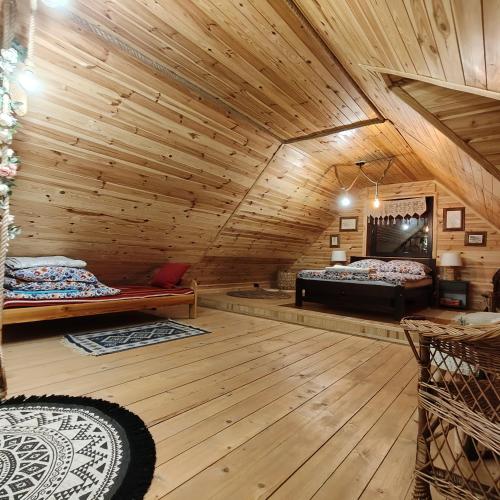 a room with two beds in a log cabin at Jałowcowe Zacisze in Brody