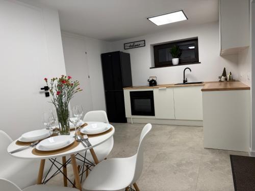a kitchen and dining room with a table and chairs at Apartament u Bacy in Nowy Targ