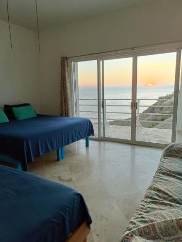 a bedroom with two beds and a view of the ocean at Hotel Luz de Mar ' right on the beach in Cuatunalco