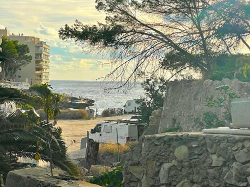 a white truck parked on a beach next to the ocean at Beachhouse 2min to the sea with pool & wonderful garden in Calvia Town