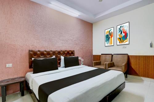 Un dormitorio con una cama grande y una silla en Collection O Haridwar Railway Station Formerly Le Central, en Haridwar