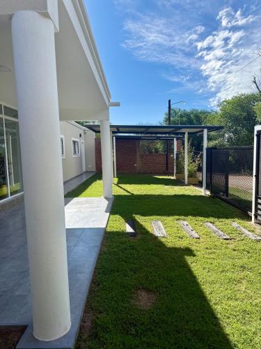 eine Terrasse mit weißen Säulen in einem Garten in der Unterkunft Copetonas in Nono