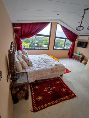 a bedroom with a bed and a large window at Tynass Ferme - Atlas Room Fes in Douar er Rouazi