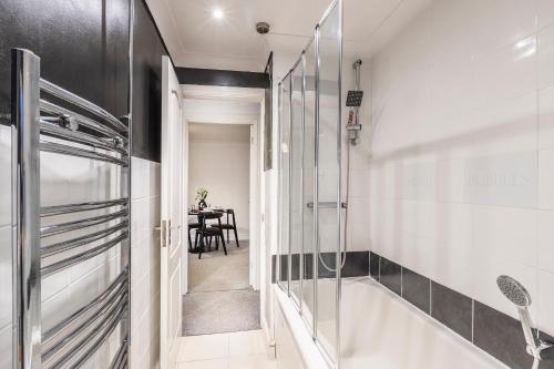 a bathroom with a shower and a bath tub at Stylish Two-Bed Apartment in Ashford in Ashford