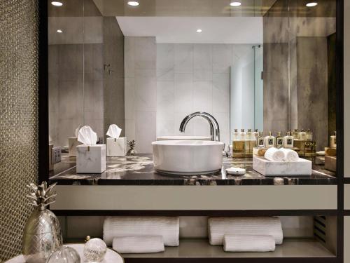 Un baño con lavabo y un espejo grande. en Fable Auckland, MGallery, en Auckland