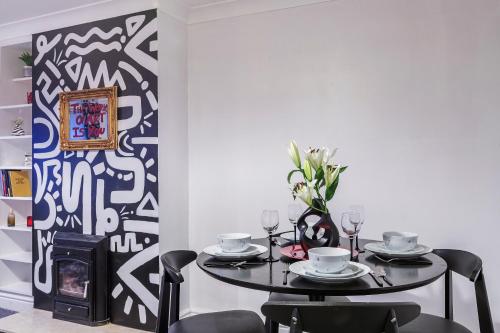 a dining room with a table and chairs and a fireplace at Stylish Two-Bed Apartment in Ashford in Ashford