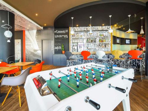ein Restaurant mit Tischfußball vor einer Bar in der Unterkunft Ibis budget Dijon Centre Clemenceau in Dijon