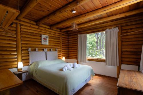 奥斯坦德Cabañas del Athuel的小木屋里有一张床的卧室