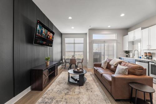 a living room with a brown couch and a table at Luxury Skyline Escape, FIFA World Cup, King Bed, Free Parking, DT View, Sauna in Dallas