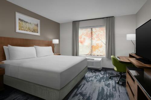 a hotel room with a bed and a television at Fairfield Inn & Suites by Marriott Jeffersonville I-71 in Jeffersonville