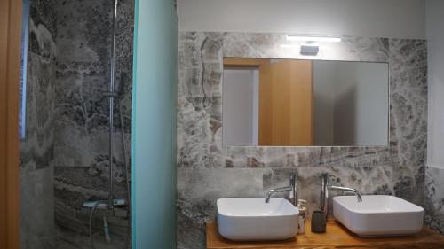 a bathroom with two sinks and a mirror at casa2sonhos in Água de Pena