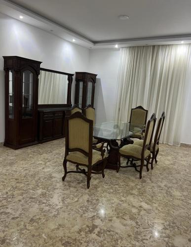 Almajidy Villa في القاهرة: غرفة طعام مع طاولة وكراسي زجاجية