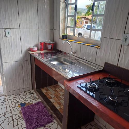 a kitchen with a sink and a stove at Pousada do Zezé in Bueno Brandão