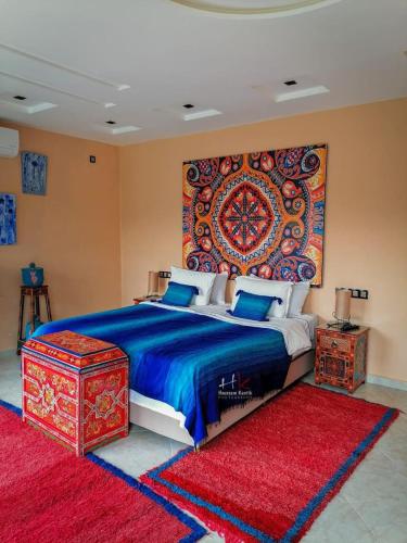 Chefchaouen Bedroom - Traditional Moroccan : غرفة نوم مع سرير مع نسيج كبير على الحائط