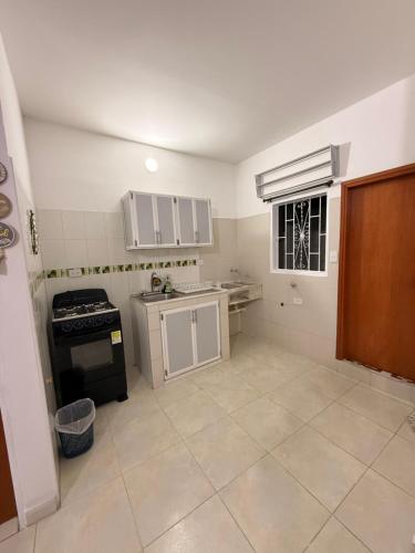 a small kitchen with white cabinets and a stove at Apartamento completo in Santa Marta