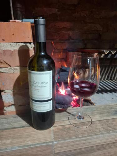 a bottle of wine next to a glass of wine at casa lucy in Puerto Iguazú