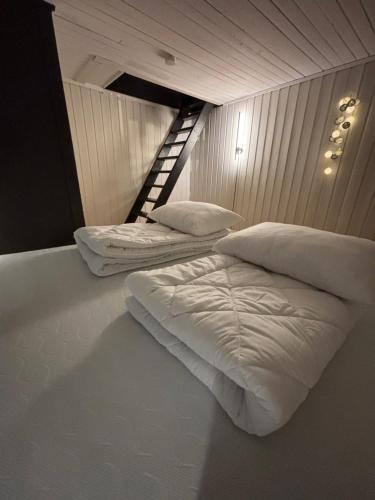 two white beds in a room with a staircase at Strandveien apartment in Narvik