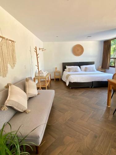 a large room with two beds and a couch at Mocca Hotels in Tepoztlán
